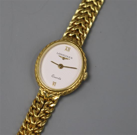 A ladys 9ct gold Longines quartz oval wrist watch, on a 9ct gold bracelet.